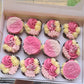 A selection of pink happy birthday cupcakes. With beautifully designed flower icing to top each cupcake
