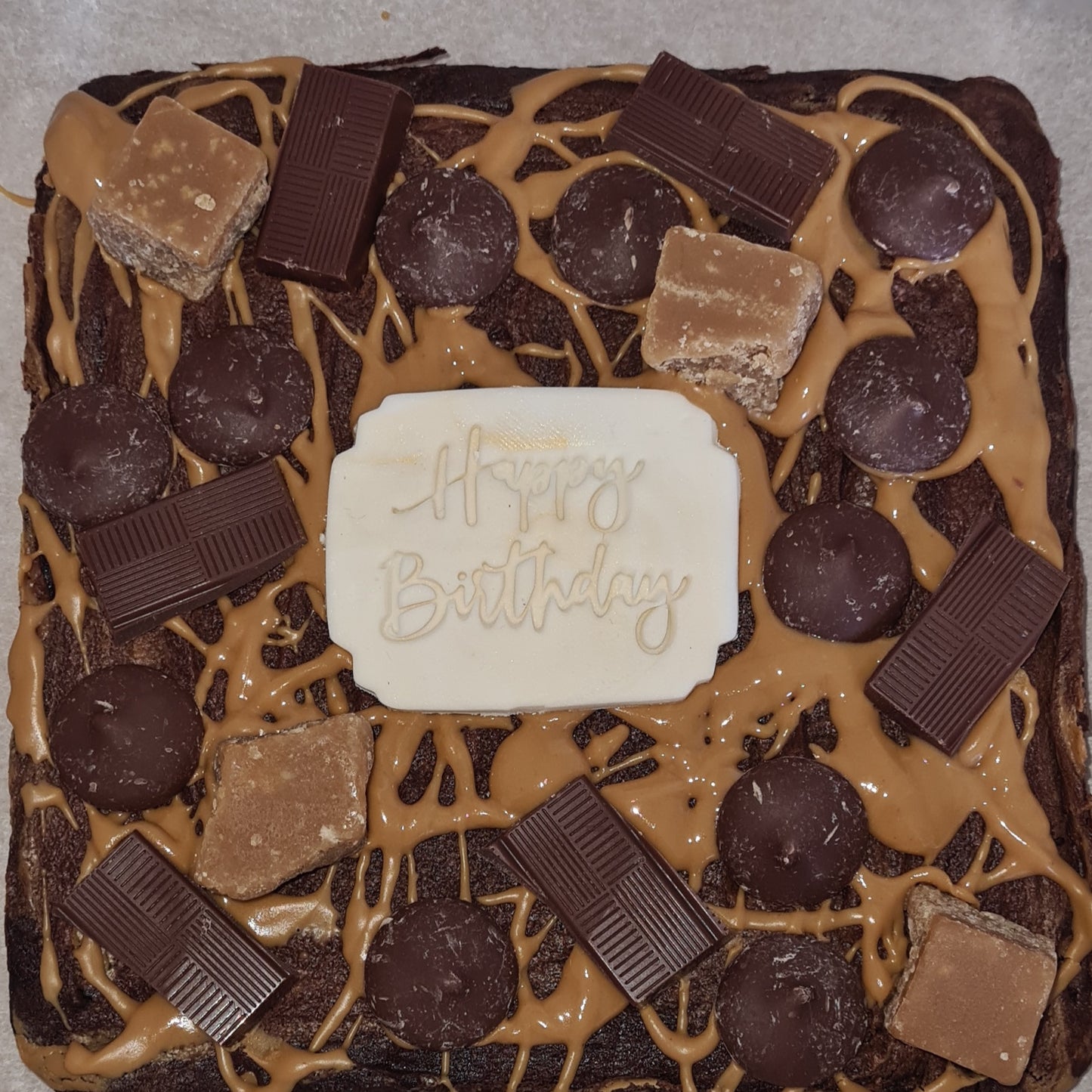 A happy birthday brownie, smothered in caramel sauce, chocolate buttons and chocolate chunks!